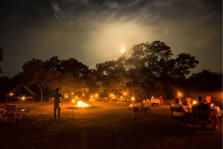 a group of people sitting arround a campsite at night wilpattu sri lanka experiential journey