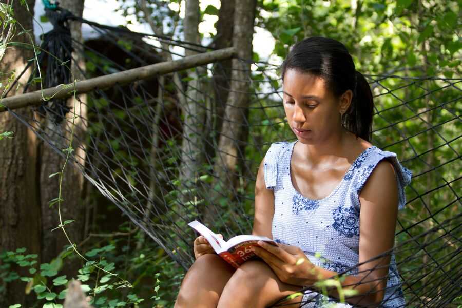 a girl relaxing by reading a book at mahoora udawalwe in sri lanka experiential journey
